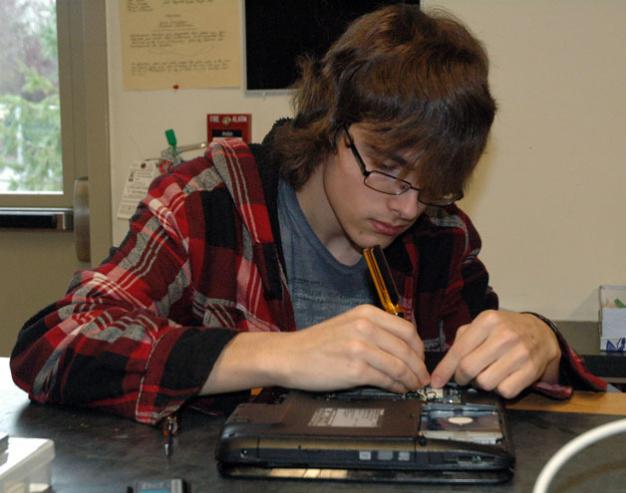 Kirk BoxleitnerMarysville Arts & Technology High School junior Mason Totten examines the inner workings of a malfunctioning laptop during the school’s repair lab class.