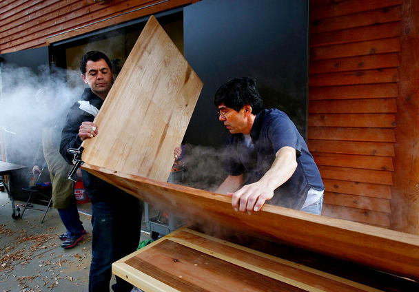 Evergreen students carve wood, imprint culture in arts program The first class of students at The Evergreen State College’s new carving shed learned to make bentwood box drums from master carver David Boxley, center, over the weekend. Clifton Guthrie, left, puts a bend in his box drum after steaming the cedar board to soften the wood.
Mark Harrison / The Seattle Times
