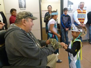 Little Miss Sunflower Emma Hall presents tribal fisherman Art Seyler with a hat during the opening ceremonies for the Chief Joseph Hatchery on Thursday. Seyler was one of several elder tribal fishermen honored during the event, which drew hundreds of people from the Confederated Tribes of the Colville Reservation, several other tribes, and numerous state and federal agencies.