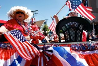 Annie Mulligan / For the heraldA red-white-and-blue-decorated truck carries people in the same colors down Fifth Avenue in Edmonds during the city's Fourth of July parade in 2012.