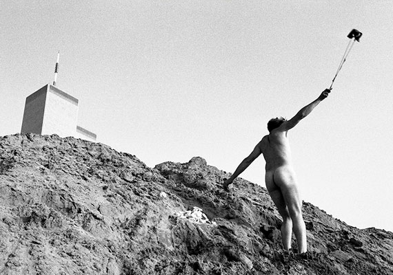 valerie silver/courtesy of the artistPHOTO-DOCUMENTATION OF AN AGITPROP PERFORMANCE He’s naked and flinging chunks of limestone at the World Trade Center, each chunk blasted with the word “PURGE.”