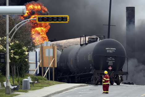 Reuters/Mathieu BelangerA firefighter walks past a burning train at Lac-Mégantic, Quebec.