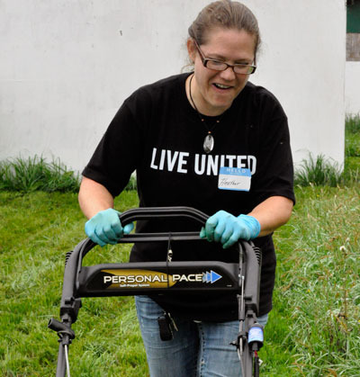 Volunteer Heather Hopingardner mows overgrown grass at the All-Breed Equine Rez-Q for United Way of Snohomish County’s annual Day of Caring.— image credit: Lauren Salcedo