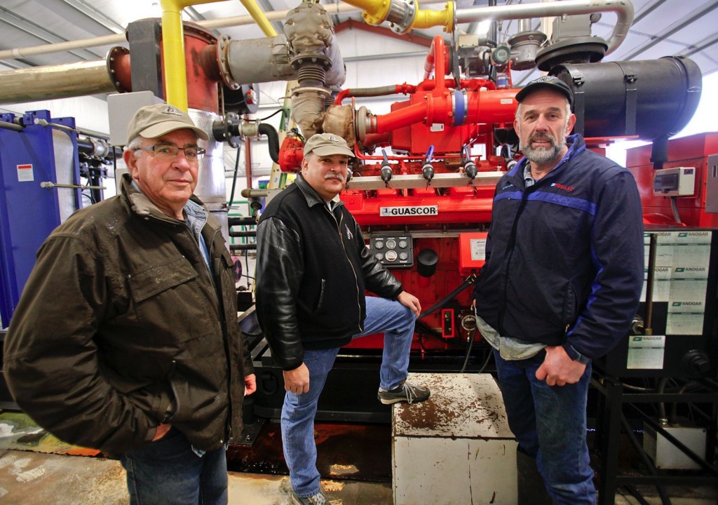 Dan Bates / The HeraldFrom left, Qualco Energy treasurer Dale Reiner president Daryl Williams and systems operator Andy Werkhoven discuss the company's complex digester system that converts cow manure to electricity on Dec. 23. Qualco Energy recently signed a contract with the Snohomish County PUD.