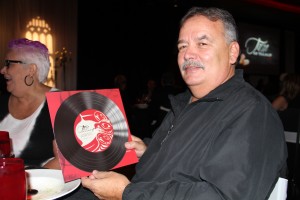 Tulalip artist Joe Gobin holds up one of the menus featuring his artwork.