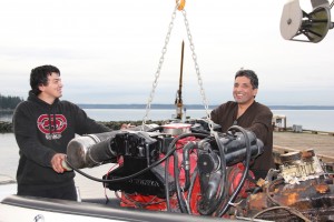 Tribal members Joe Hatch Jr and Joe Hatch Sr working together to install a rebuilt motor.