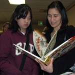 Isabelle, left, and Mimi Santos check out an art drawing book up for bid at the March 1 “Parker’s Cure” silent auction in support of the Marysville-Pilchuck High School Life Skills Program. Photo: Kirk Boxleitner
