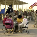 Drum circle during the 120th Engineer Combat Battalion pow wow at Al Taqaddum Air Base, Iraq, 2004. Photo by Master Sergeant Chuck Boers (Lipan Apache/Oklahoma Cherokee, b. 1964). Gift of Sergeant Debra K. Mooney and members of the 120th Engineer Combat Battalion. Smithsonian National Museum of the American Indian