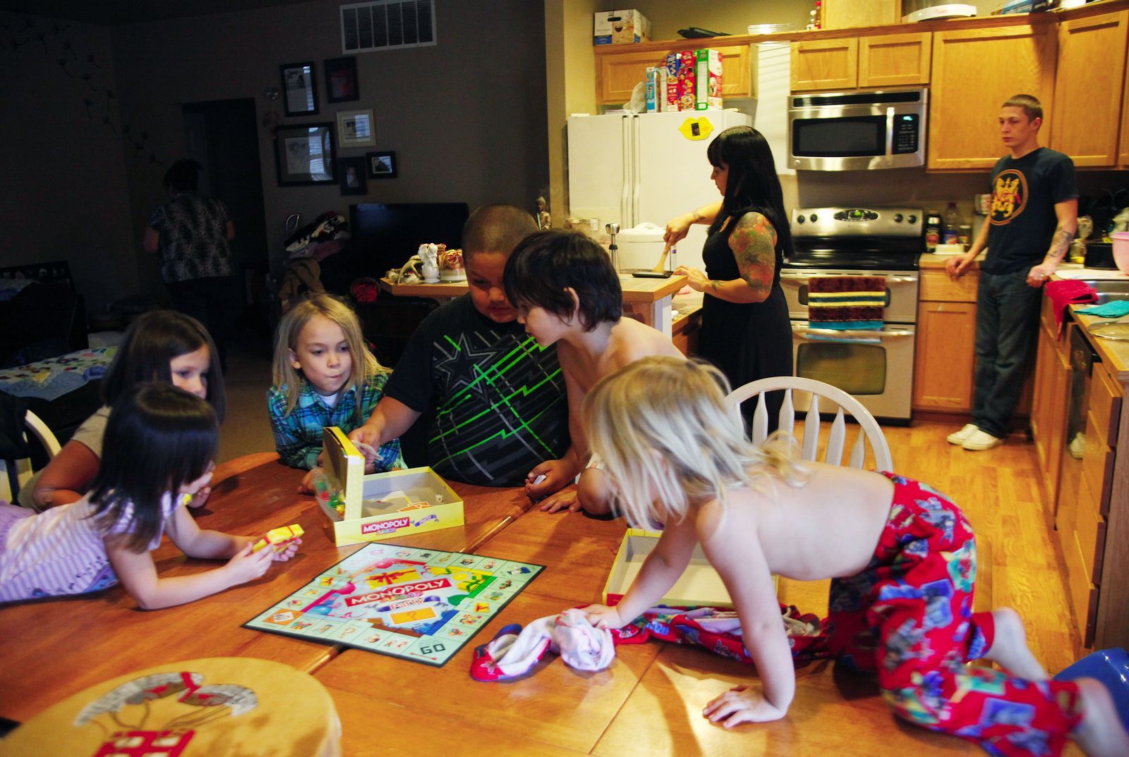 Genna Martin / The HeraldFrom left, Katie Hots, 4; Calista Weiser, 5; KC Hots, 7; Irwin Weiser, 8; Kane Hots, 5; and Aloisius Williams, 2, play Monopoly as Natasha Gobin and her spouse, Thomas Williams, make dinner at their home in Tulalip. Gobin, who teaches Lushootseed language classes, asks her children, KC, Kane, Katie and Aloisius, to count in Lushootseed as they play the game.