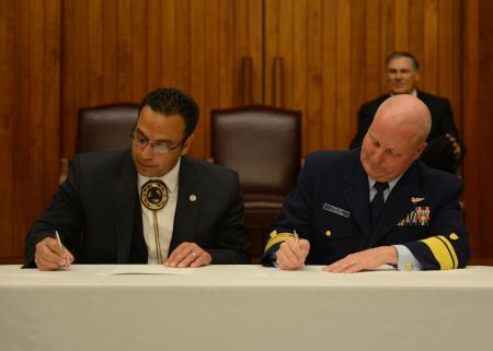 Rear Adm. Keith A. Taylor, commander of the 13th Coast Guard District, and the honorable Timothy J. Greene Sr., chairman of the Makah Tribal Council, sign a memorandum of agreement at the Jackson Federal Building in Seattle, April 12, 2013. 