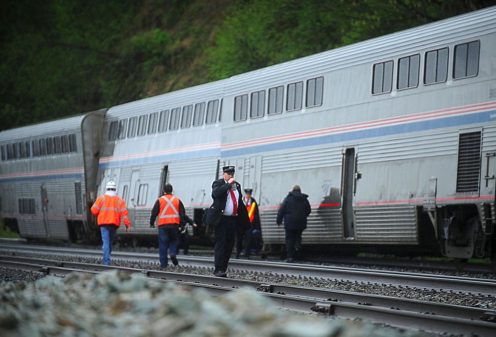 Doug Ramsay / For the HeraldBurlington Northern Santa Fe and Amtrak officials examine the last two coaches of the Chicago to Seattle Empire Builder that derailed just north of Howarth Park in Everett on Sunday morning. There were no injuries in the derailment and passengers from the derailed cars were moved to the front cars as the train continued to Seattle with the two derailed cars being left behind.