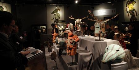 A visitor looks at antique tribal masks revered as sacred ritual artifacts by a Native American tribe in Arizona which are displayed at an auction house in Paris April 11, 2013. REUTERS/John Schults