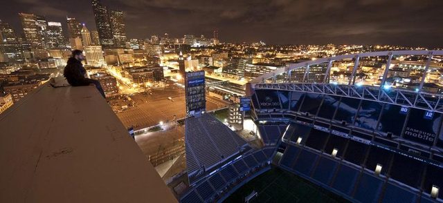 An unidentified climber sits atop the roof of Seattle's Century Link FieldPhoto by Reddit/Shuttersubversive