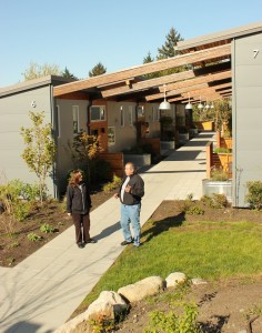 Annette Bryan, director of the Puyallup Tribal Housing Authority, and Ted Franzen, a resident at “The Place of Hidden” waters chat outside the new environmentally friendly building.
