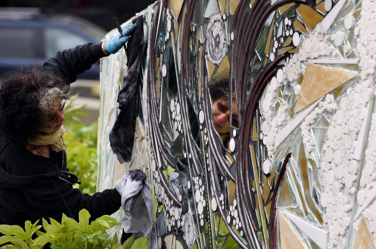 Jennifer Buchanan / The HeraldArtist Linda Beaumont is reflected in part of her mosaic installation at the new Wetmore Theater Plaza in downtown Everett.