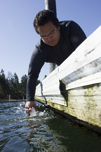 Nisqually natural resources technician Jimsan Dunstan samples water at Johnson Point in Olympia.