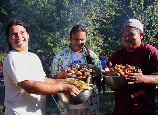 Participants from the 2012 Our Food is Our Medicine Conference hold up vegetables cooked in a traditional pit oven. Photo courtesy of NWIC