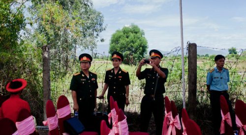 Against the backdrop of a field contaminated by Agent Orange in Da Nang, Vietnamese military officers attended a ceremony on Thursday to mark the United States’ first big cleanup of war chemicals in Vietnam. Photo: Maika Elan/AP