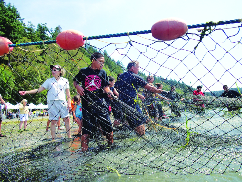 Community members work together, hauling in fishing nets. Photo/Niki Cleary