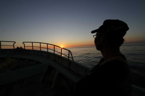 In this Aug. 26, 2013 photo, fisherman Fumio Suzuki watches the sunrise aboard his boat Ebisu Maru before the star of fishing in the waters off Iwaki, about 40 kilometers (25 miles) south of the tsunami-crippled Fukushima Dai-ichi nuclear power plant, Japan. Suzuki's trawler is one of 14 at his port helping to conduct once-a-week fishing expeditions in rotation to measure radiation levels of fish they catch in the waters off Fukushima. Fishermen in the area hope to resume test catches following favorable sampling results more than two years after the disaster, though for now fishing is suspended due to leaks of radiation-contaminated water from storage tanks at the nuclear power plant. Photo: Koji Ueda 