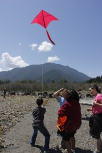 Campers from NatureBridge Science Camp fly a kite over the former Lake Aldwell, with a camera attached to the flyline.