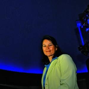 Annette Lee sits in the planetarium with constellations behind her at Cloud State University. (Photo by Stacy Thacker/St. Cloud Times)