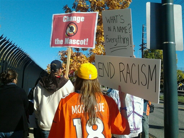 Courtesy Tessa McLeanDemonstrators march with signs toward Invesco Field in Denver, Colo., to protest the Washington Redskins name as the team arrived at the stadium, Oct. 27, 2013. 