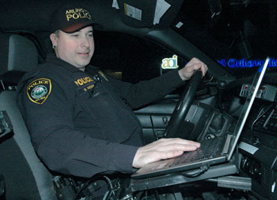 Arlington Police Officer Erik Moon checks his computer before driving his patrol car out for the ‘Night of 1,000 Stars’ impaired driving emphasis on Dec. 13.— image credit: Kirk Boxleitner