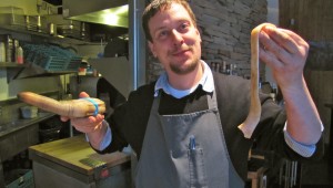 Michael Gifford, chef at Seattle's How To Cook A Wolf, shows off a geoduck he's preparing. | credit: Ashley Ahearn 