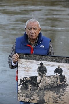 Ted S. Warren / Associated PressBilly Frank Jr., a Nisqually tribal elder who was arrested dozens of times while trying to assert his native fishing rights during the Fish Wars of the 1960s and ‘70s, holds a late-1960s photo of himself Monday (left) fishing with Don McCloud, near Frank’s Landing on the Nisqually River. Several state lawmakers are pushing to give people arrested during the Fish Wars a chance to expunge their convictions from the record.