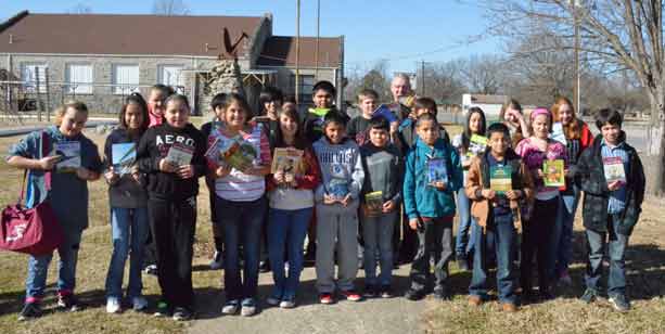 Oaks Mission sixth-graders stand with teacher Jerry Jackson outside the school with some of the books donated by East Brainerd Intermediate School in Chattanooga, Tenn.