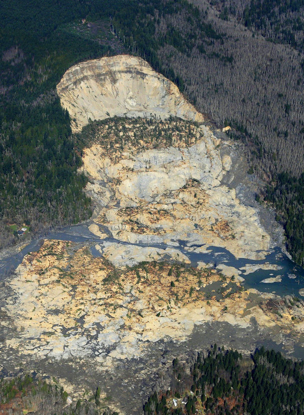 Associated Press photo State allowed logging on plateau above slopeThis aerial photo, taken after Saturday’s landslide, shows part of the plateau that has been logged over the decades. Right above where the hill fell away is a 7½-acre patch, shaped like a triangle, that was clear-cut about nine years ago. 