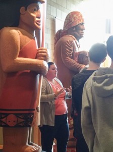 Hibulb Cultural Center Tour Specialist Mary Jane Topash discusses the craft of the welcoming figures carved by James Madison and Joe Gobin. Photo/ Brandi N. Montreuil, Tulalip News 
