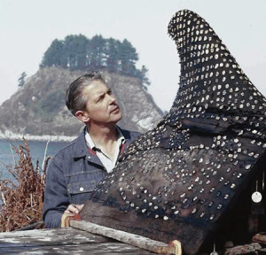 In this undated photo, WSU archaeologist Richard Daugherty looks at the effigy of a whale fin found among thousands of artifacts at the Ozette site on the Olympic Peninsula.