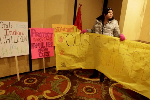 Dana Fast Horse carries posters at the American Civil Liberties Union press conference in Rapid City on March 21, 2013. Families and tribes claim that temporary custody hearings were too short and violated rights guaranteed under the 14th Amendment. Court reporters who produced the transcripts during the hearings have until June 1 to produce the files. Photo/ Rapid City Journal