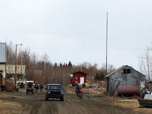 FILE - In this May 7, 2014, file photo, residents make their way along First Street in the village of Tanana, Alaska. Without a jail or even armed law enforcement, the isolated Alaska village where two state troopers were shot and killed is turning to a traditional form of justice: banishment. The Tanana Village Council, the Athabascan Indian tribal authority in the village of 250, is taking steps to expel two men whose actions contributed to the homicides and who have threatened other community members, council Chairman Curtis Sommer said. (AP Photo/Fairbanks Daily News-Miner, Eric Engman, File)