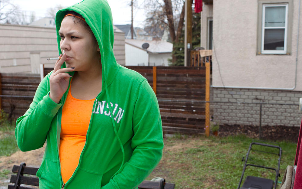 Ricki LaMorie, of Hayward, Wis., smokes a cigarette outside her grandmother Margie LaMorie's home while visiting during Mother's Day weekend Thursday, May 8, 2014 in Minneapolis. LaMorie said she knows that smoking is bad for her health and tries not to do it often. Jennifer Simonson/MPR News
