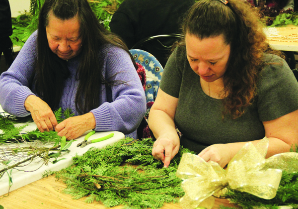 Mother and daughter, Pat Contraro and Sara Andreas work side-by-side making holiday wreaths. Photo/Micheal Rios