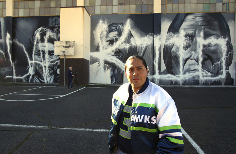 Muralist Andrew Morrison filed a police report Monday for damage done over the weekend to his Native American murals on the side of the Wilson-Pacific school building. (Mark Harrison / The Seattle Times)