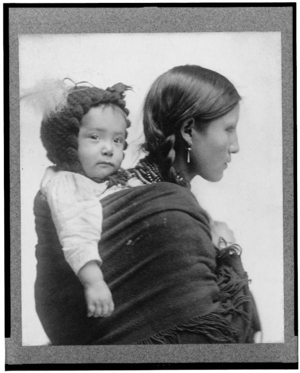 Library of Congress Prints and Photographs Division Washington, D.C.This image shows a Native woman from the Plains region carrying a baby on her back.