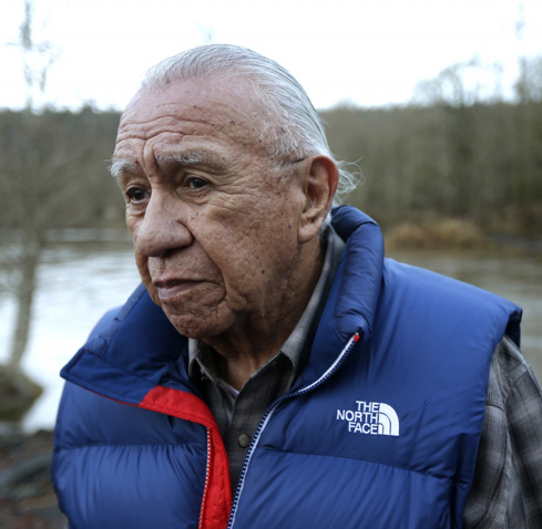 Billy Frank Jr. poses for a 2014 photo near Frank’s Landing on the Nisqually River in Nisqually, Wash. Frank, a Nisqually tribal elder who was arrested dozens of times while trying to ‘assert his native fishing rights during the Fish Wars of the 1960s and ’70s. (AP Photo/Ted S. Warren, File)