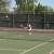 Coach from England teaching tennis to Pine Ridge students